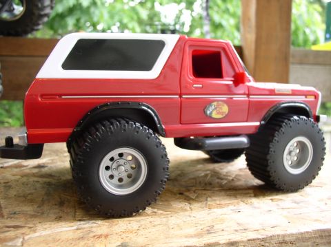 1979 Ford Bronco - This red toy Bronco, matching the 1979 model year, features a white removable top and oversized off-road tires.