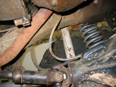 1992 Ford Mustang - Close-up view of the undercarriage components, including suspension and exhaust parts, on a vehicle.