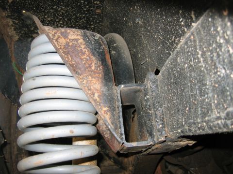 1992 Ford Mustang - Close-up view of a vehicle's suspension system, showing a coil spring and frame elements.