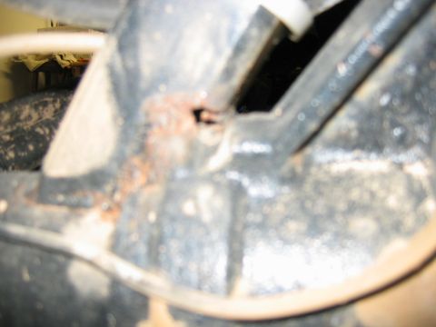 1992 Ford Mustang - A close-up view of a rusted metal bracket with wires, showing signs of wear and tear.