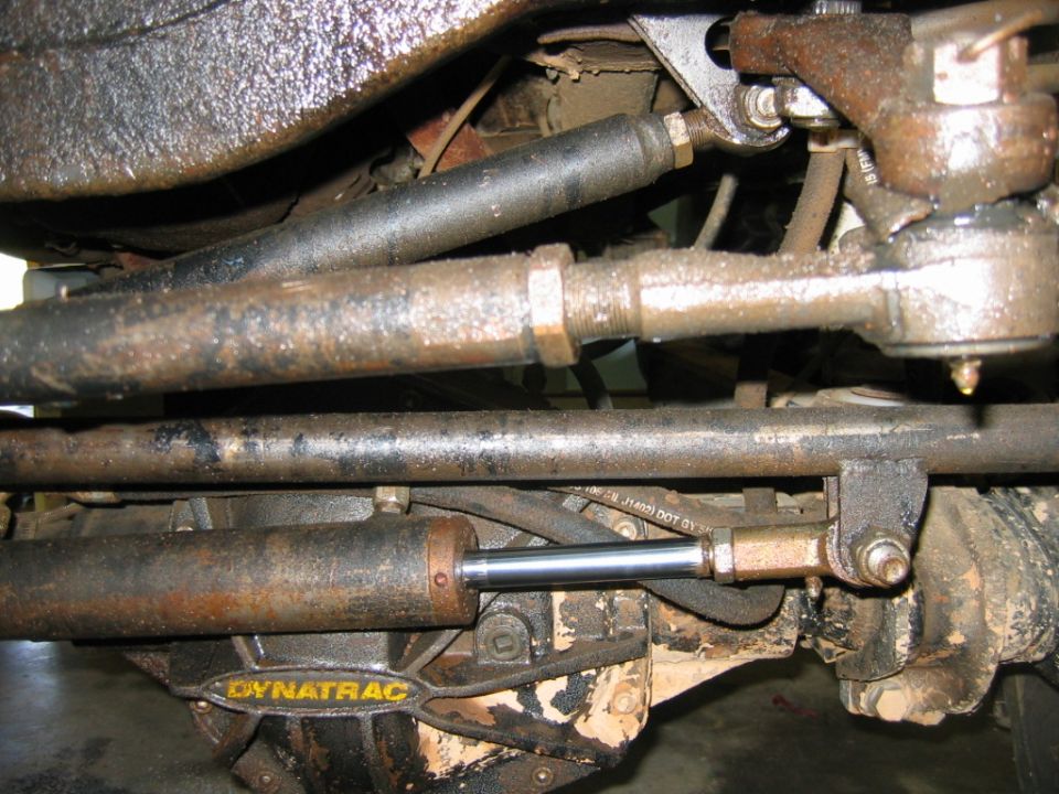 Close-up of steering linkage and Dynatrac shock absorber on a vehicle's front axle