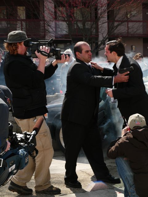 1985 Ford LTD Crown Victoria - A film crew captures a dramatic scene involving two men in suits and a smoking car.
