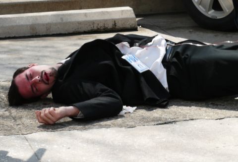 1985 Ford LTD Crown Victoria - A man in a suit lies on the ground, appearing to be injured, with an FBI badge visible.