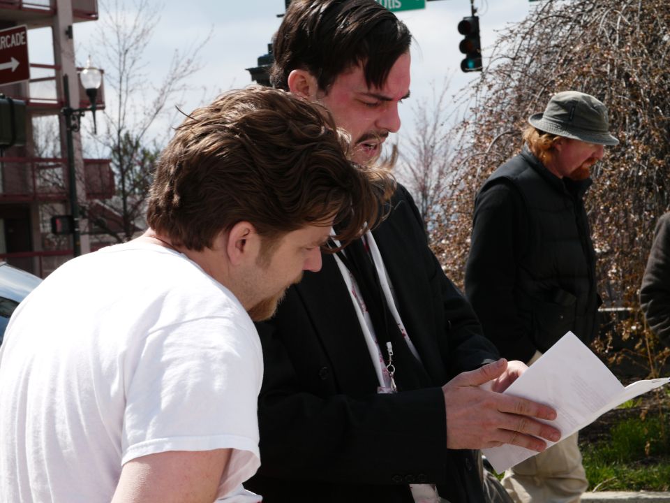 People gathered outdoors, looking at a document