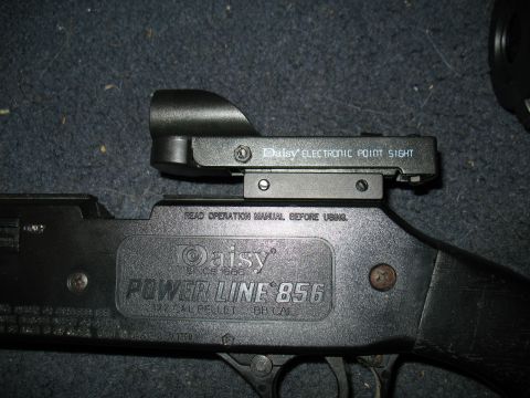 1997 Ford Crown Victoria - Close-up of a Daisy Power Line 856 air rifle, a Daisy electronic point sight and "Read Operation Manual Before Using" text.