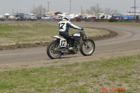 2006 Honda CBR-RR - A motorcycle racer wearing a blue and white jacket with the number 17 speeds around a dirt track.