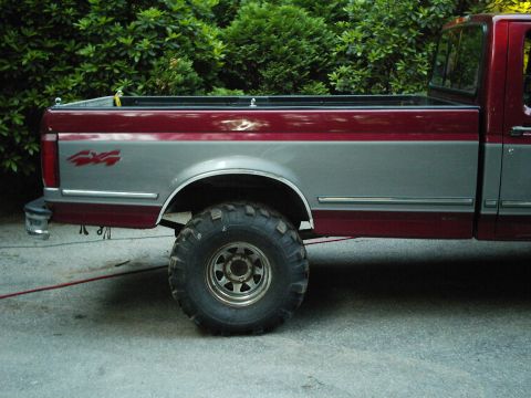 1994 Ford F-150 - This pickup truck features a two-tone paint scheme with a prominent 4x4 decal on the rear quarter panel.