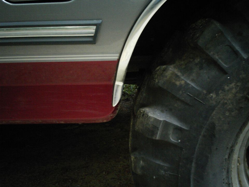 1994 Ford F-150 rear fender with red lower body panel and large off-road tire