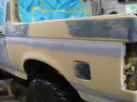 1996 Ford Bronco - Body repair in progress on a 1996 Ford Bronco, showing primer and filler on the rear quarter panel.