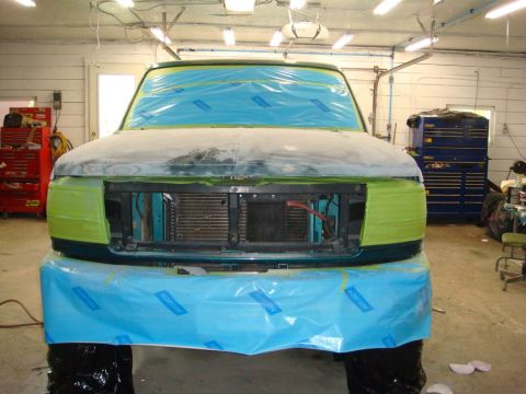 1996 Ford Bronco - A vehicle is prepped for body repair in a workshop, with masking tape and plastic covering the front end.