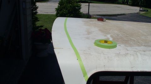 1979 Ford Bronco - A roll of green masking tape and a sander sit on the roof of a vehicle, ready for work.