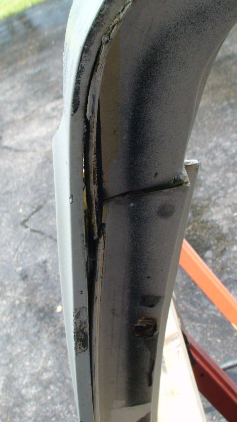 1979 Ford Bronco - Detail of a corroded and bent car door frame, indicating significant wear and tear.