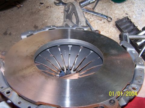 1979 Ford F-150 - A vehicle's clutch assembly is shown with visible wear and rust, alongside various tools.
