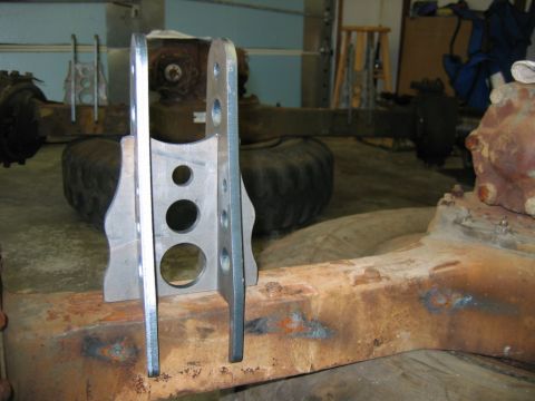 1992 Ford Mustang - Custom suspension brackets are shown attached to a heavily rusted axle assembly in a garage setting.