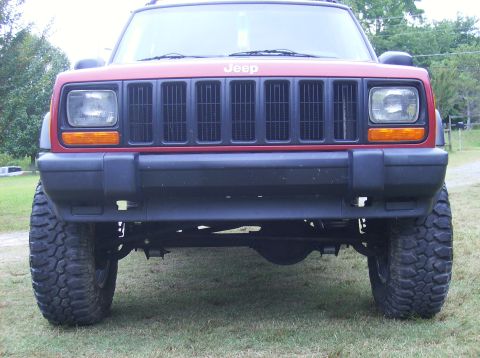 1998 Jeep Cherokee - This Jeep Cherokee features a prominent grille and off-road tires, suggesting a model year around 1997.