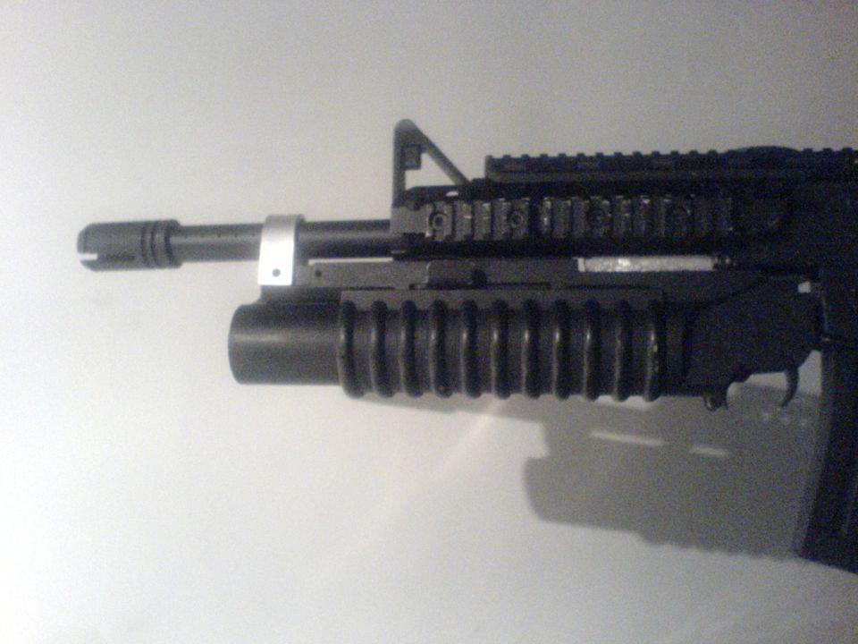 Close-up of a firearm barrel and grenade launcher attachment.
