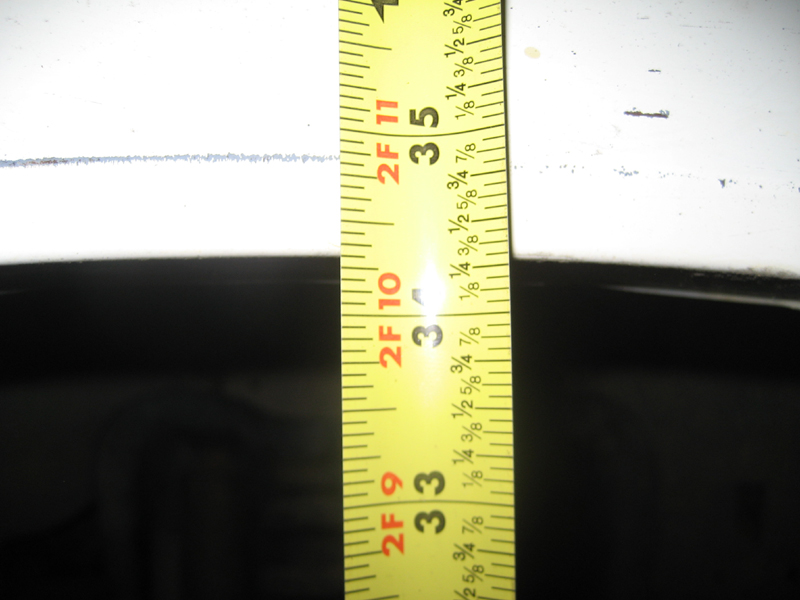 Yellow measuring tape showing inches from 33 to 35 against a white surface.