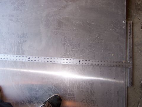 1991 Ford Bronco - Photograph of a sheet of aluminum on the floor with measuring rulers laid across it.