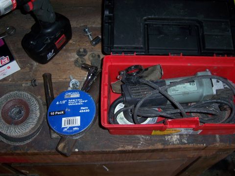 1991 Ford Bronco - Photograph of a workbench holding a cordless drill, angle grinder and a pack of metal cut-off wheels.