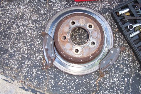 1992 Ford Crown Victoria - A brake rotor and pads are shown next to a tool kit on a textured surface.