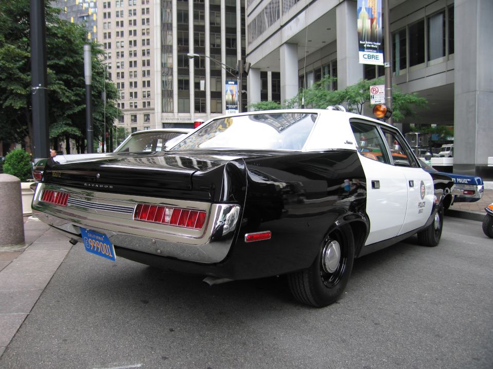 Rear three-quarter of black-and-white AMC Matador police car on city sidewalk