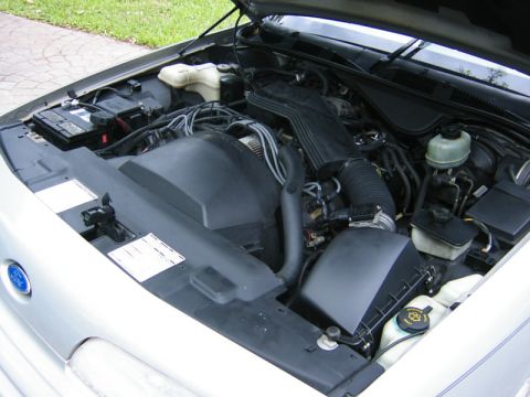 1992 Ford Crown Victoria - The engine bay of a silver car is visible with the hood open, showing various components and wiring.