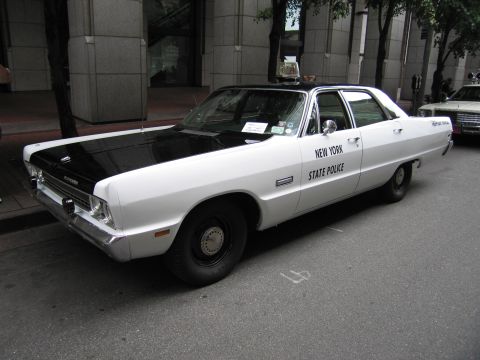 1991 Ford LTD Crown Victoria - vintage white and black New York State Police sedan with a single roof light sits parked along a city curb.