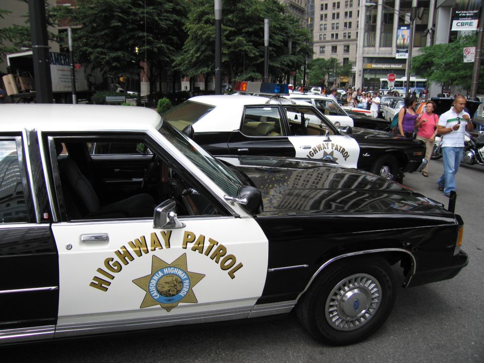 Black and white Ford California Highway Patrol cruisers parked in a row