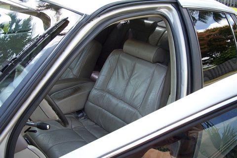1992 Ford Crown Victoria - The interior of a car features gray leather seats and a view of the outside through the windows.