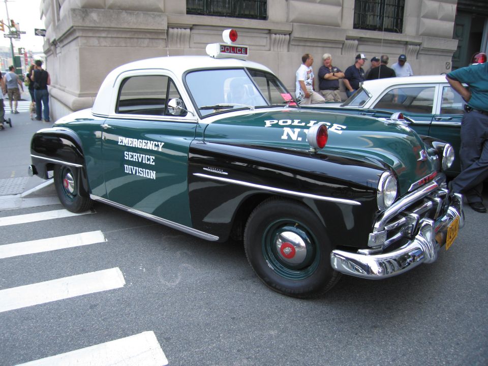 Green and black NYPD Emergency Service Division coupe with white roof and dome light