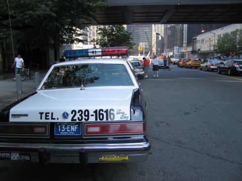 1991 Ford LTD Crown Victoria - Rear view of a vintage black-and-white police sedan lettered TEL. 239-1616 with a Connecticut municipal plate, parked under an overpass.