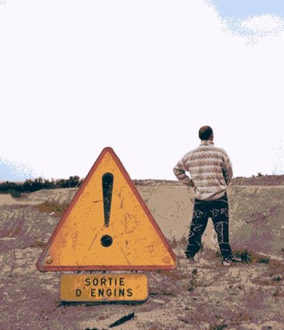 1991 Ford Crown Victoria - A warning sign indicating 'Exit of machinery' stands near a person in an outdoor scene.