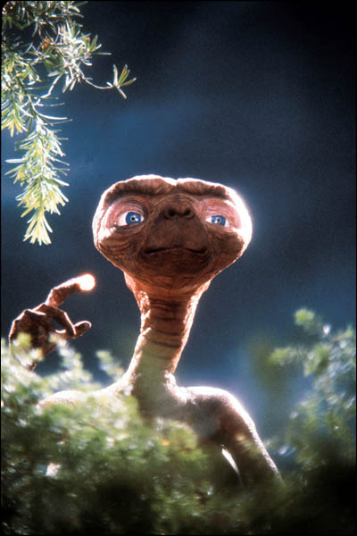 1991 Ford Crown Victoria - E.T. the Extra-Terrestrial peeks out from behind bushes, pointing a glowing finger.