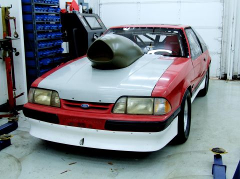 1990 Ford Mustang - Modified 1990 Ford Mustang drag car with prominent hood scoop and racing interior.