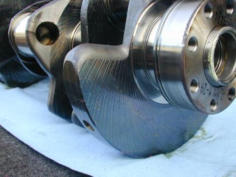 2007 Ford Mustang - This is a close-up view of a crankshaft, a critical engine component, showing its machined surfaces and mounting flange.