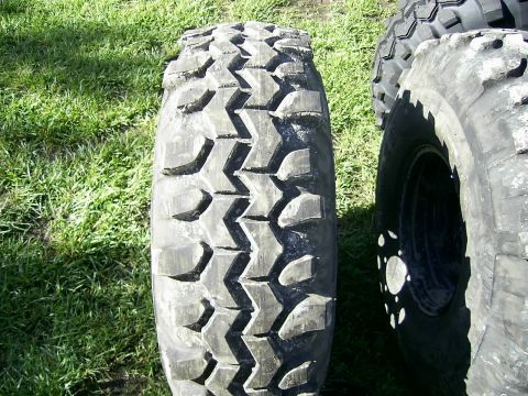 1978 Ford Bronco - Two off-road tires are shown, one in focus with a tread pattern.