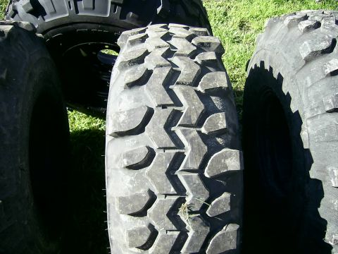 1978 Ford Bronco - Several large, tires are shown resting on grass, with a watermark for Supermotors.net visible.