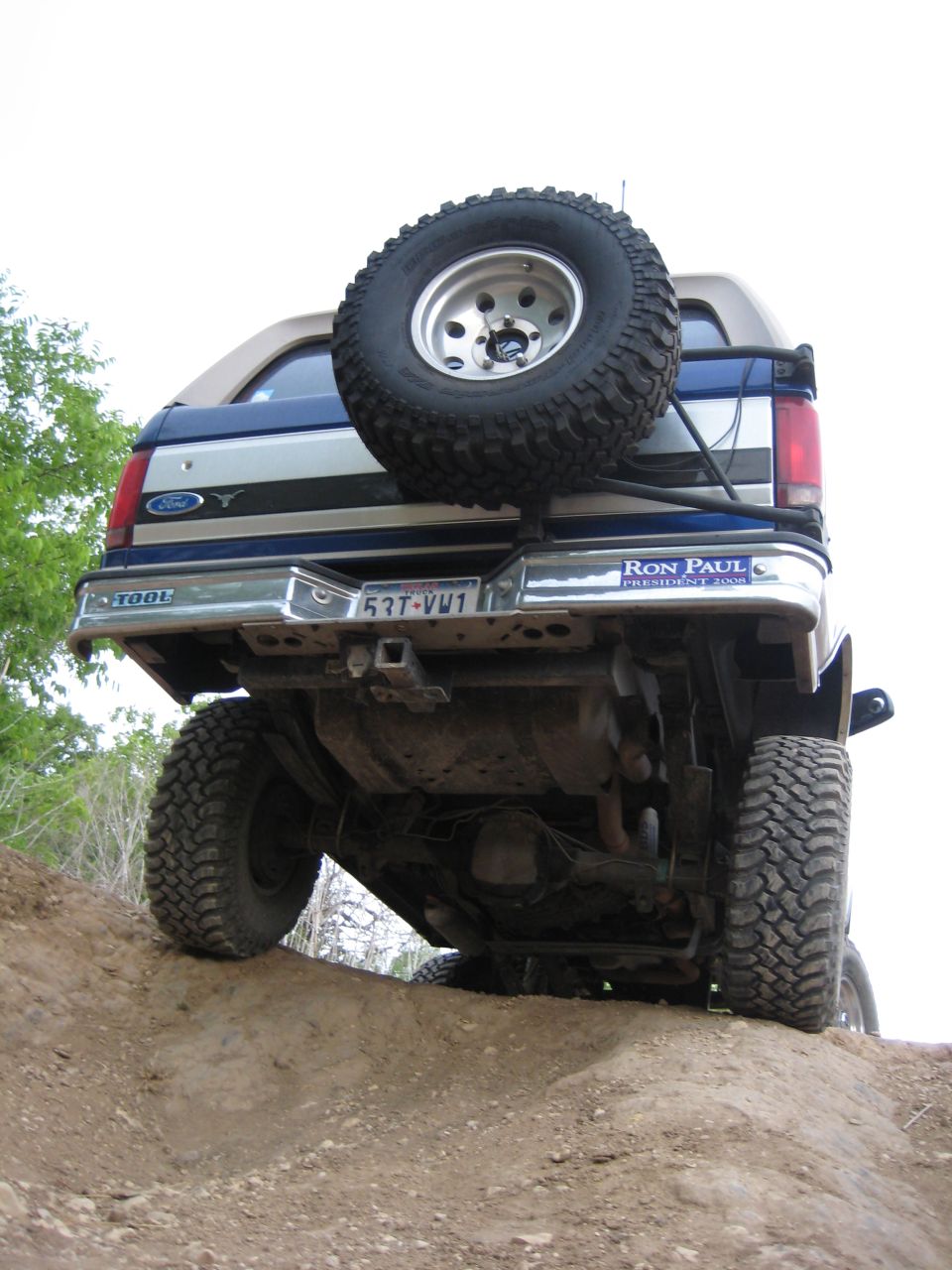 1996 Ford Bronco rear view, blue and silver, spare tire on back, off-road