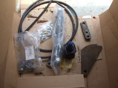 1987 Suzuki Samurai - Various vehicle parts are laid out inside a cardboard box, including hoses and metal components.