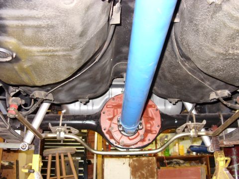 1978 Ford Mustang II - Underside view looking up at a freshly rebuilt rear axle, with the differential housing and third-member cover painted orange-red and a blu…