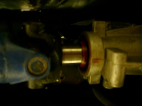 1978 Ford Mustang II - Dim close-up under a car of a steering shaft U-joint, with a blue-painted yoke on the left mating to a splined shaft entering a cast steeri…