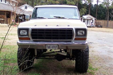 1979 Ford Bronco front view, beige, lifted, with a black grille and chrome bumper