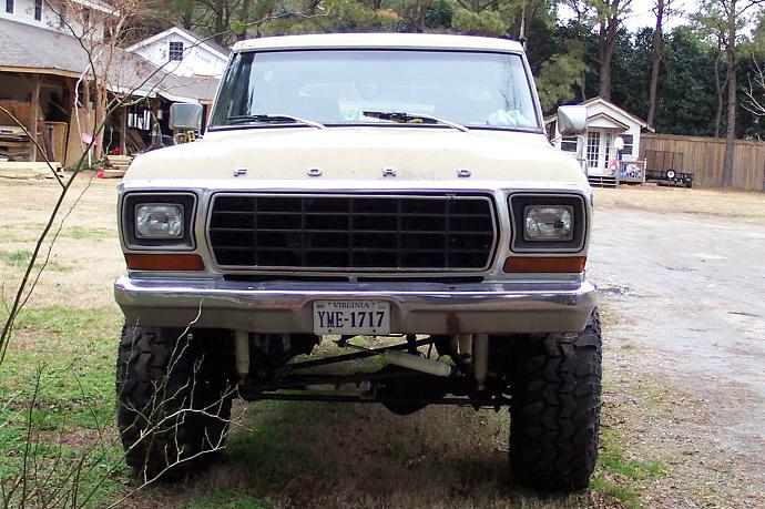 1979 Ford Bronco front view, beige, lifted, with a black grille and chrome bumper
