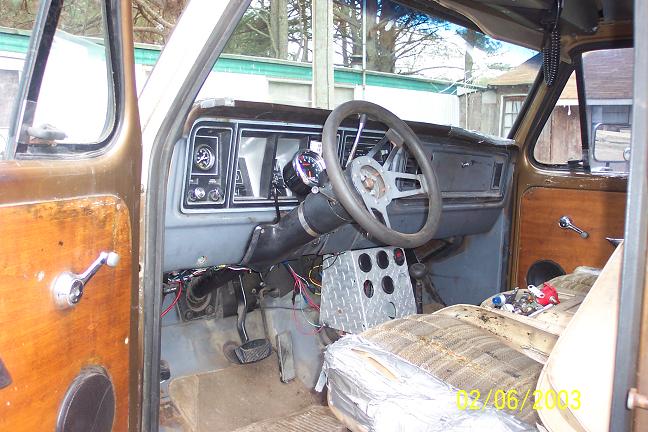 Interior of a brown 1973 Ford Bronco showing the dashboard, steering wheel, and driver's seat