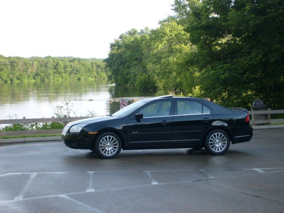 Black Mercury Milan sedan side profile parked in a riverside parking lot