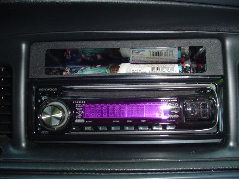 2000 Ford Crown Victoria - Close-up of a car's dashboard showing a car stereo and a storage slot with items inside.