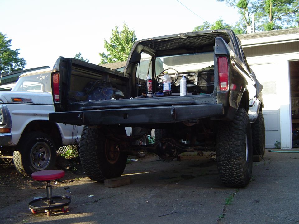 Lifted black Ford Bronco from the rear with tailgate off and body lifted, exposing rear axle