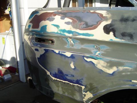 1978 Ford Bronco - Vehicle bodywork is being prepped for paint, showing various layers of primer and filler.