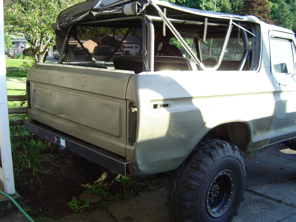 1978 Ford Bronco rear quarter panel, tailgate, and large off-road tire. Soft top is up