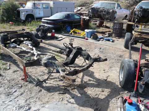 1975 Ford Ranchero - Various car frames and parts are visible in an outdoor salvage yard.